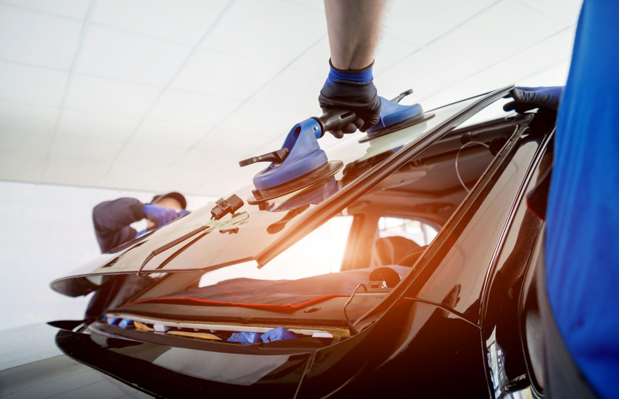 dreamstime_m_183253490 Automobile special workers replacing windscreen of a car in auto service. Automobile special workers replacing windscreen or windshield of a car in auto service station garage. Background